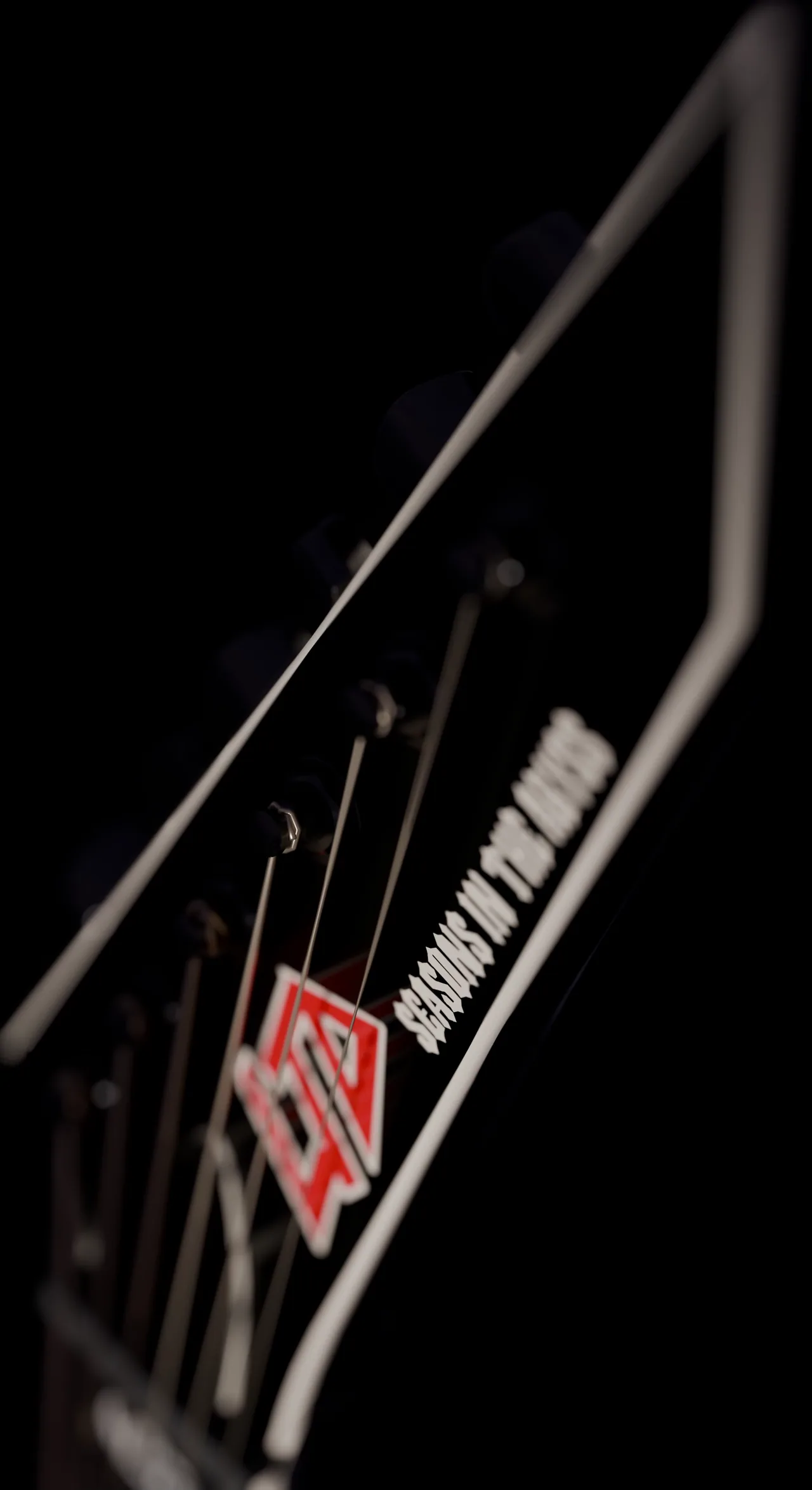 three signature electric guitars lit against black